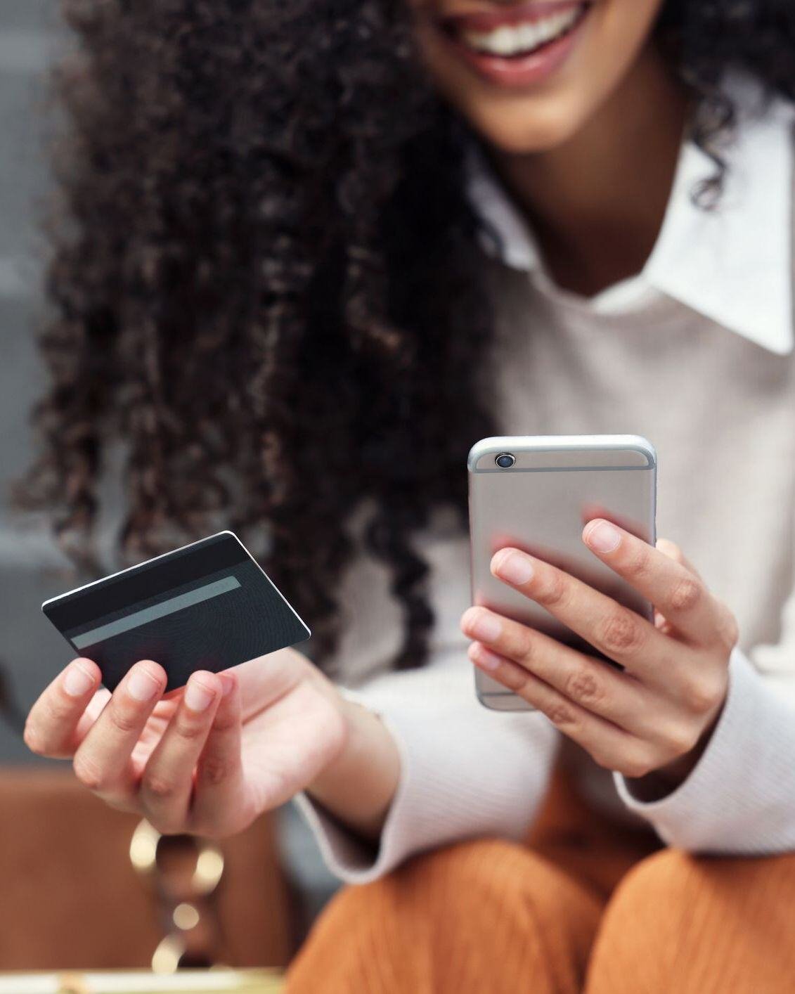 woman holding credit card and iphone